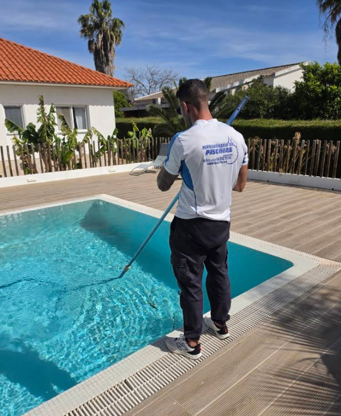 Técnico a limpar uma piscina com equipamento profissional